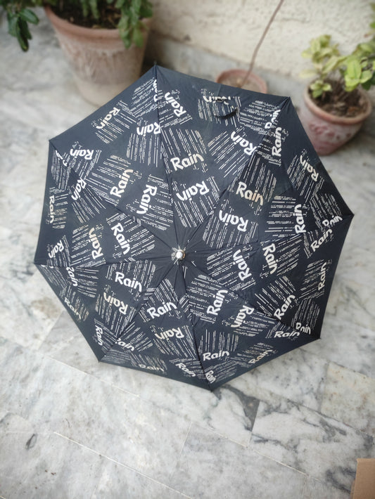 BLACK FOLDING UMBRELLA WITH AN ALL OVER RAIN TEXT PATTERN
